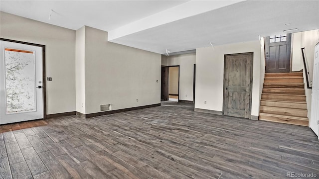 spare room featuring plenty of natural light and dark hardwood / wood-style floors