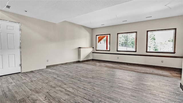 unfurnished room featuring hardwood / wood-style floors and a textured ceiling