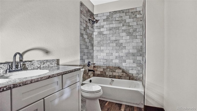 full bathroom with vanity, toilet, tiled shower / bath combo, and hardwood / wood-style floors