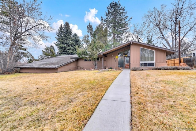 view of front of property with a front lawn and fence