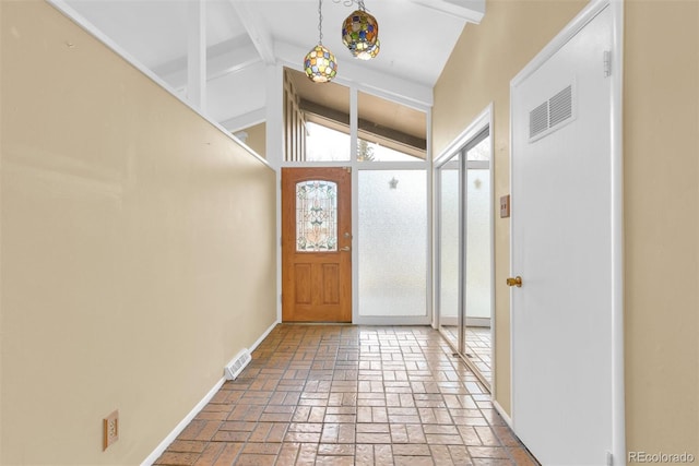 entrance foyer with visible vents, baseboards, lofted ceiling with beams, and brick floor