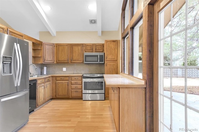 kitchen with a sink, beamed ceiling, light countertops, appliances with stainless steel finishes, and open shelves