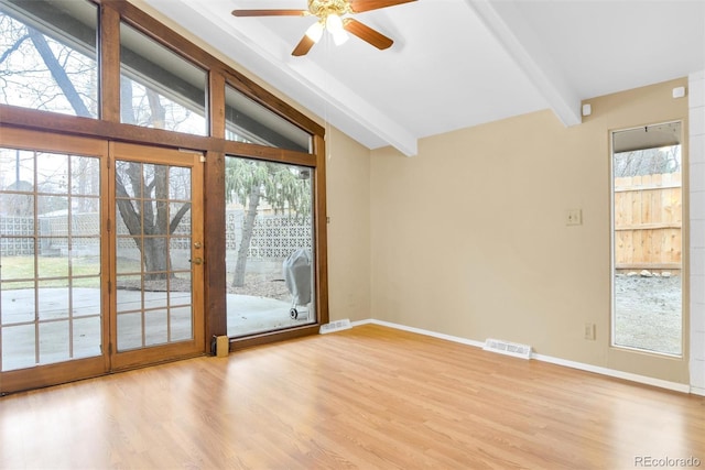 spare room featuring lofted ceiling with beams, wood finished floors, visible vents, and baseboards