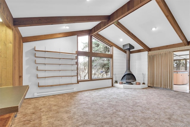 unfurnished living room with wooden walls, carpet, a baseboard radiator, lofted ceiling with beams, and a wood stove