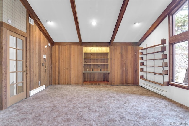 carpeted empty room featuring lofted ceiling with beams, a baseboard radiator, visible vents, and wood walls