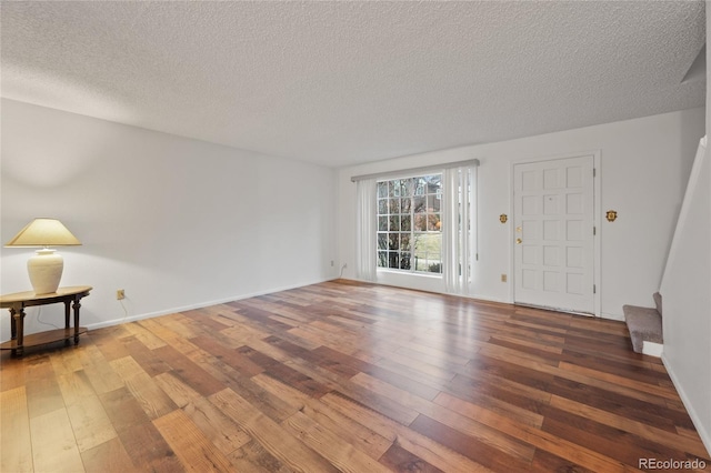 unfurnished living room featuring a textured ceiling and wood-type flooring