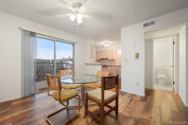 dining space featuring ceiling fan, dark wood-type flooring, and a textured ceiling