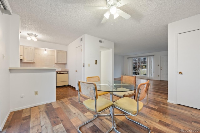 dining room featuring wood-type flooring, a textured ceiling, and ceiling fan