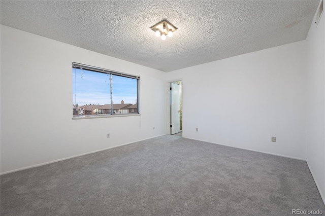 carpeted spare room featuring a textured ceiling