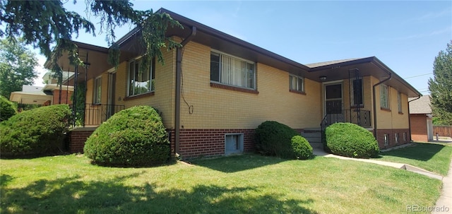 view of property exterior with a lawn and brick siding