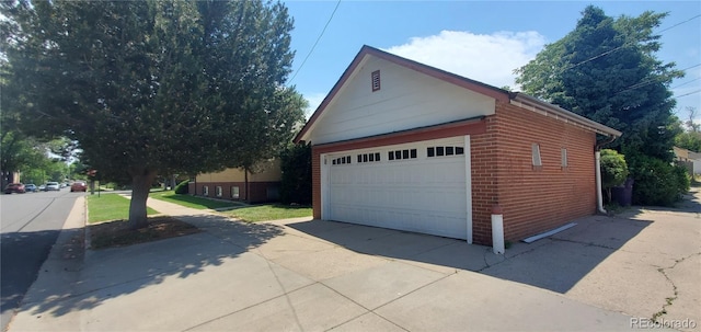 exterior space with brick siding, a detached garage, and an outdoor structure