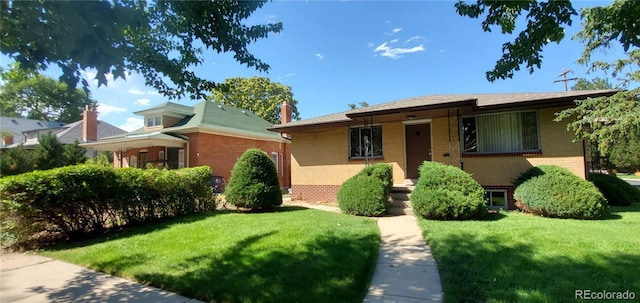 view of front of property featuring a front lawn and brick siding