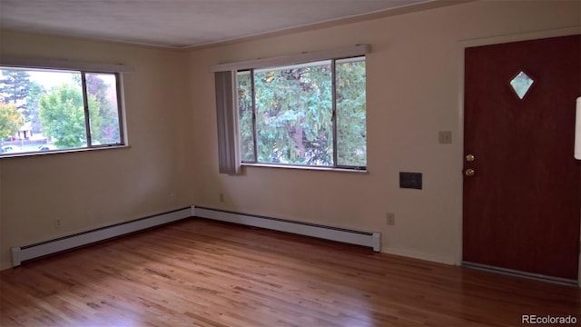 foyer entrance featuring a baseboard radiator and wood finished floors