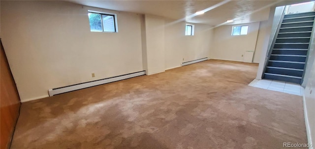 below grade area featuring plenty of natural light, baseboard heating, and carpet floors