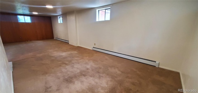 basement featuring carpet flooring and a baseboard heating unit