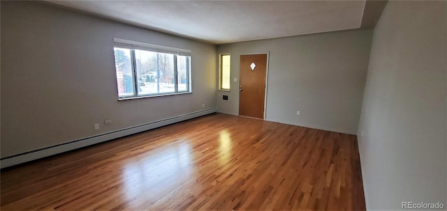 interior space with wood finished floors and a baseboard radiator