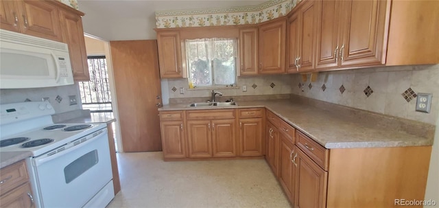 kitchen with white appliances, plenty of natural light, light countertops, and a sink