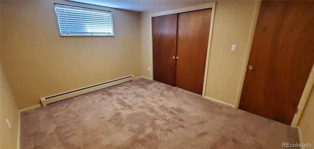 unfurnished bedroom featuring a closet, a baseboard heating unit, and carpet