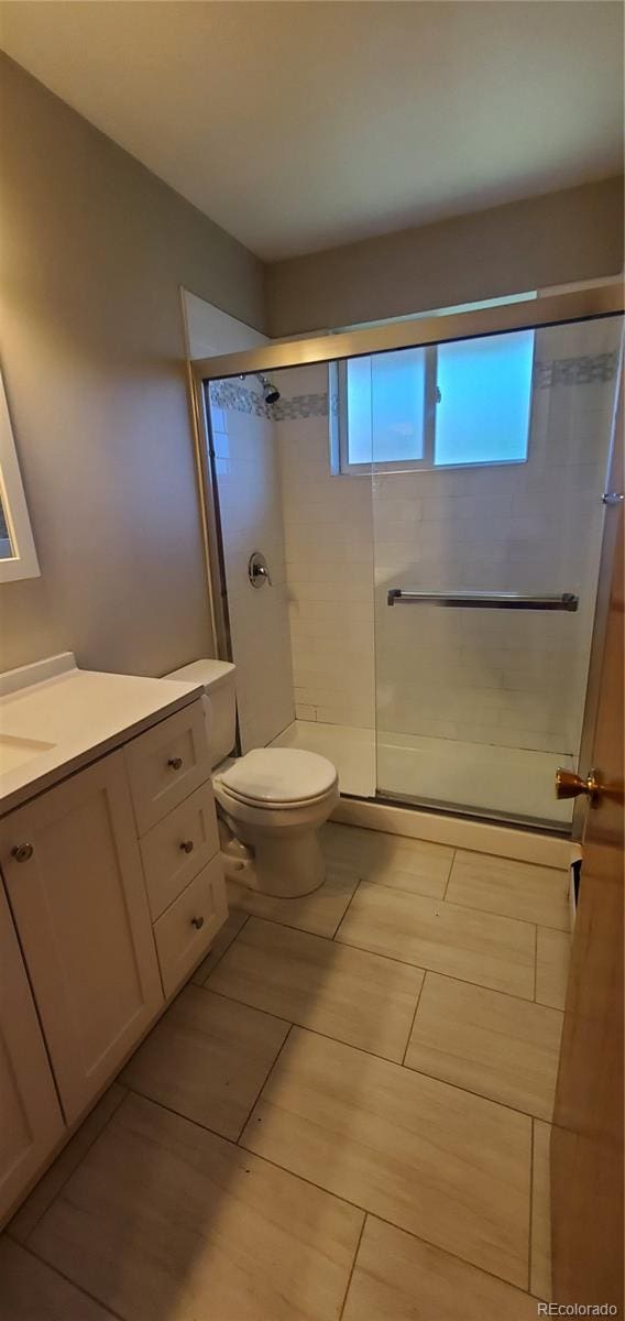 2903-2905 W 39th Ave, Denver, CO 80211 - full bath with vanity, toilet, tile patterned floors, and a shower with door