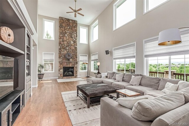 8993 Stonecrest Way, Highlands Ranch, CO 80129 - living area with a towering ceiling, ceiling fan, a fireplace, and wood finished floors
