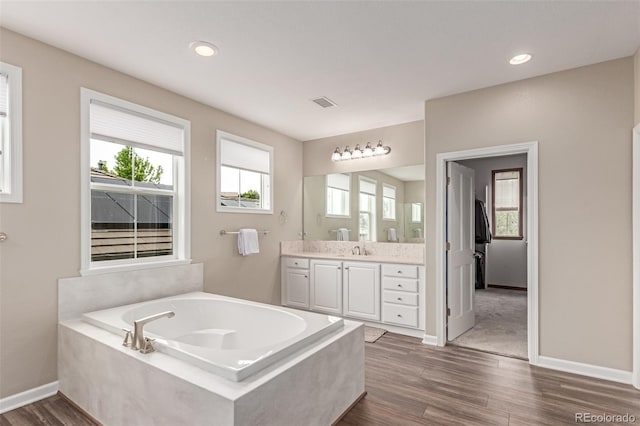 8993 Stonecrest Way, Highlands Ranch, CO 80129 - bathroom with vanity, wood finished floors, a bath, baseboards, and recessed lighting
