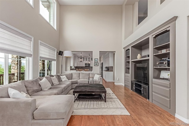 8993 Stonecrest Way, Highlands Ranch, CO 80129 - living room with a high ceiling, wood finished floors, and baseboards