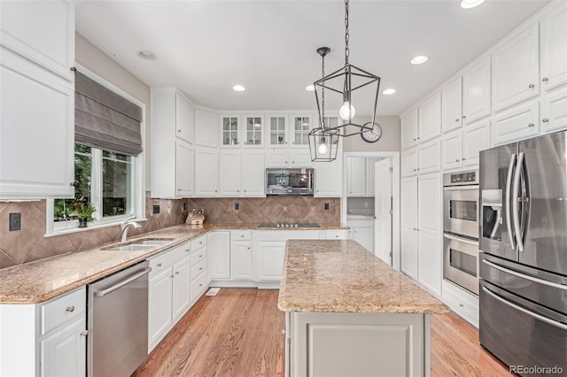 8993 Stonecrest Way, Highlands Ranch, CO 80129 - kitchen with appliances with stainless steel finishes, a sink, a kitchen island, white cabinets, and recessed lighting