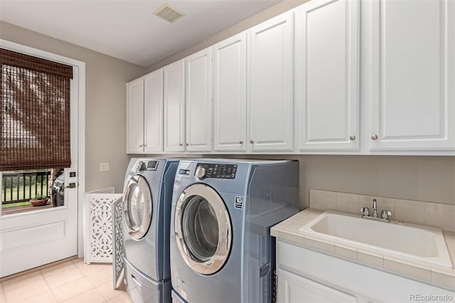8993 Stonecrest Way, Highlands Ranch, CO 80129 - washroom featuring washer and clothes dryer, cabinet space, and light tile patterned floors