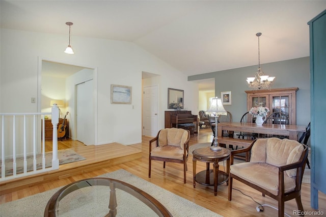 interior space featuring vaulted ceiling, a notable chandelier, and light wood-type flooring