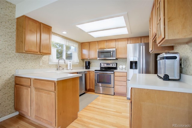 kitchen featuring sink, appliances with stainless steel finishes, and light hardwood / wood-style flooring