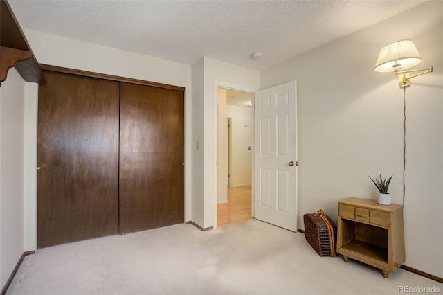 carpeted bedroom featuring a closet and a textured ceiling