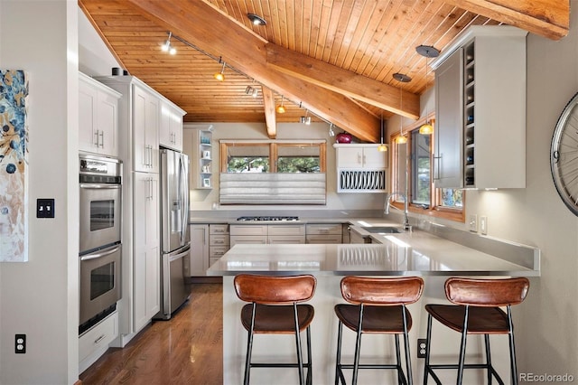 kitchen with sink, kitchen peninsula, white cabinets, wood ceiling, and appliances with stainless steel finishes