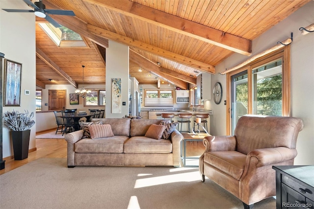 living room featuring beam ceiling, a skylight, plenty of natural light, wood ceiling, and ceiling fan with notable chandelier