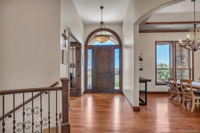 19336 Queens Crescent Way, Monument, CO 80132 - foyer with arched walkways, a chandelier, wood finished floors, and baseboards