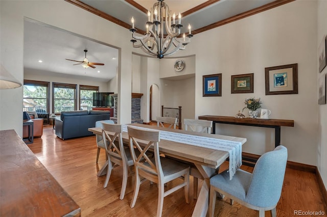 19336 Queens Crescent Way, Monument, CO 80132 - dining area featuring ceiling fan, arched walkways, light wood-style floors, a chandelier, and crown molding