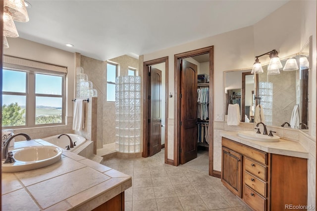 19336 Queens Crescent Way, Monument, CO 80132 - bathroom with tile patterned floors, vanity, walk in shower, a garden tub, and a walk in closet