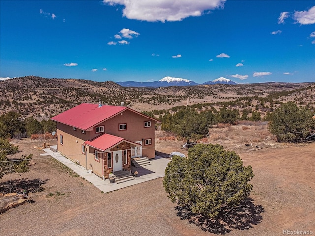 view of front of property featuring a patio area and a mountain view