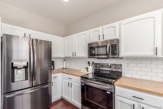 kitchen featuring decorative backsplash, white cabinetry, appliances with stainless steel finishes, and butcher block countertops