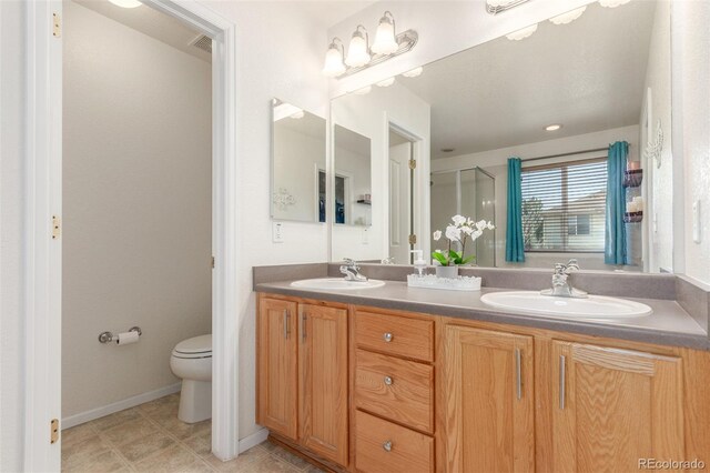 bathroom featuring a sink, toilet, double vanity, and tile patterned flooring