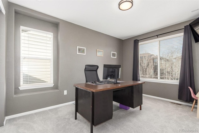 office area with visible vents, light colored carpet, and baseboards