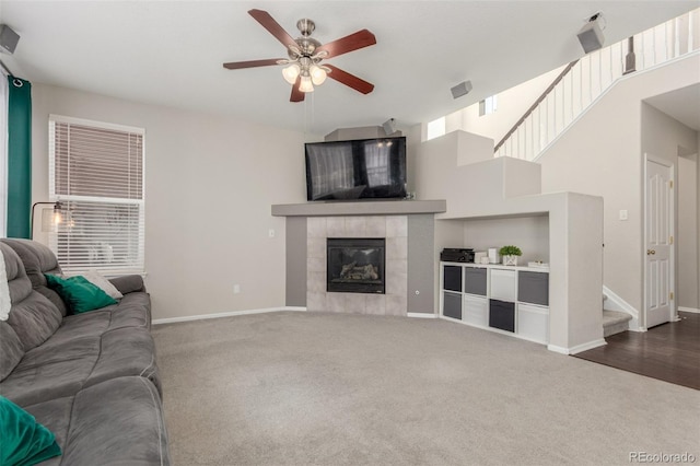 carpeted living room featuring visible vents, baseboards, a ceiling fan, and a fireplace