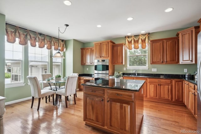 5603 Van Bibber Ct, Golden, CO 80403 - kitchen with brown cabinetry, stainless steel double oven, pendant lighting, a center island, and recessed lighting