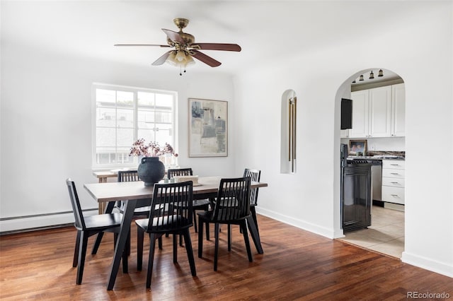 2895 S Sherman St, Englewood, CO 80113 - dining space with a ceiling fan, light wood-type flooring, arched walkways, and a baseboard radiator