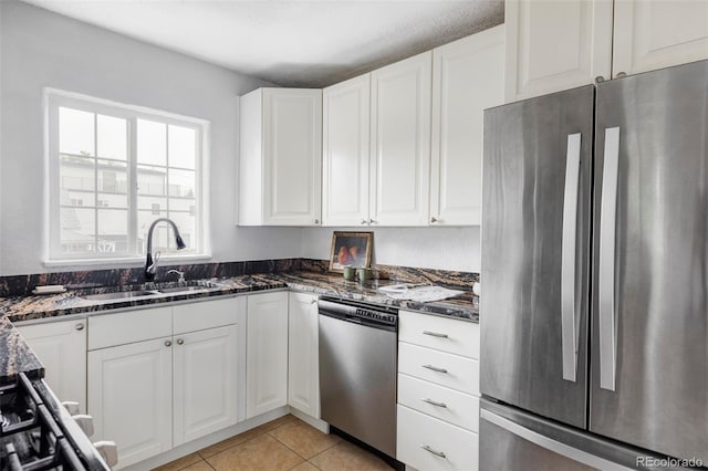 2895 S Sherman St, Englewood, CO 80113 - kitchen with appliances with stainless steel finishes, dark stone counters, white cabinetry, and light tile patterned flooring