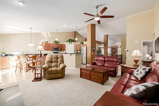 living room featuring ceiling fan, light tile patterned flooring, and lofted ceiling