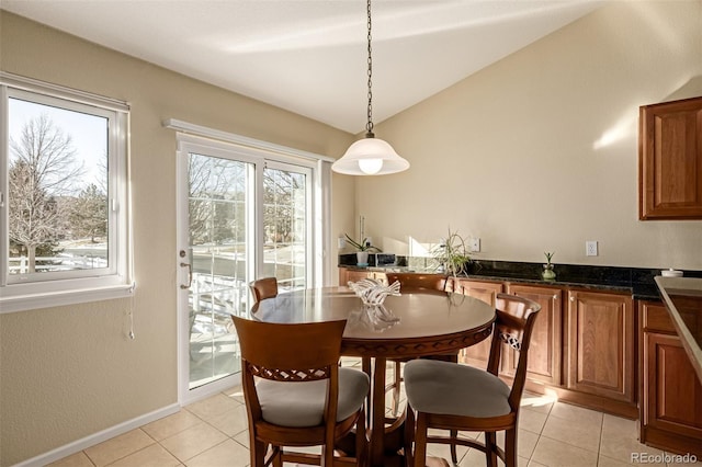 dining space featuring light tile patterned floors and vaulted ceiling