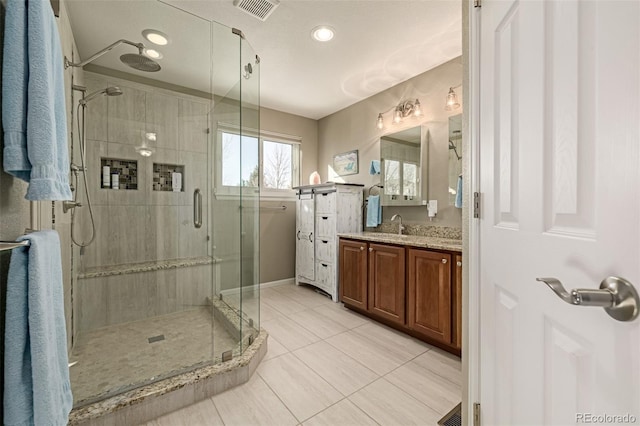 bathroom featuring walk in shower, tile patterned floors, and vanity