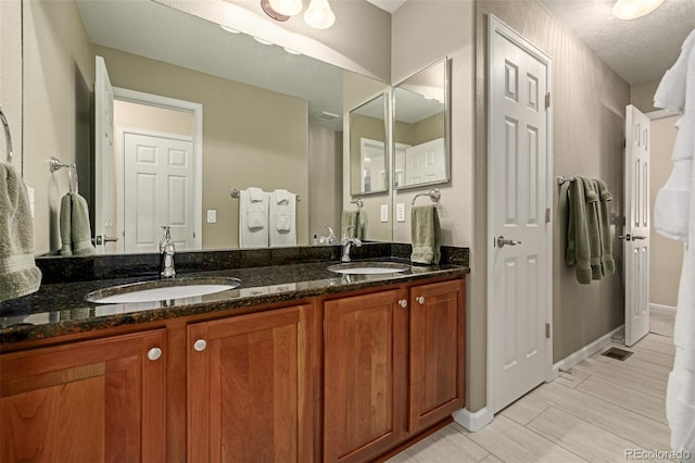 bathroom with a textured ceiling and vanity