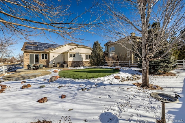 view of front of home featuring a patio area and solar panels