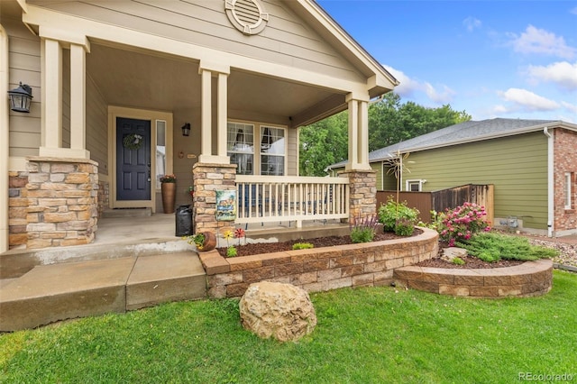 1831 Ashford Cir, Longmont, CO 80504 - entrance to property with covered porch, stone siding, and a lawn